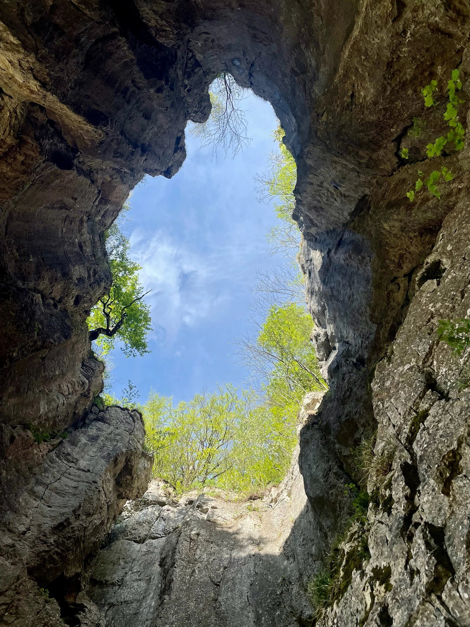 A person gazing up at a clear blue sky, arms raised, symbolizing a connection with the universe and the expression of dreams and desires