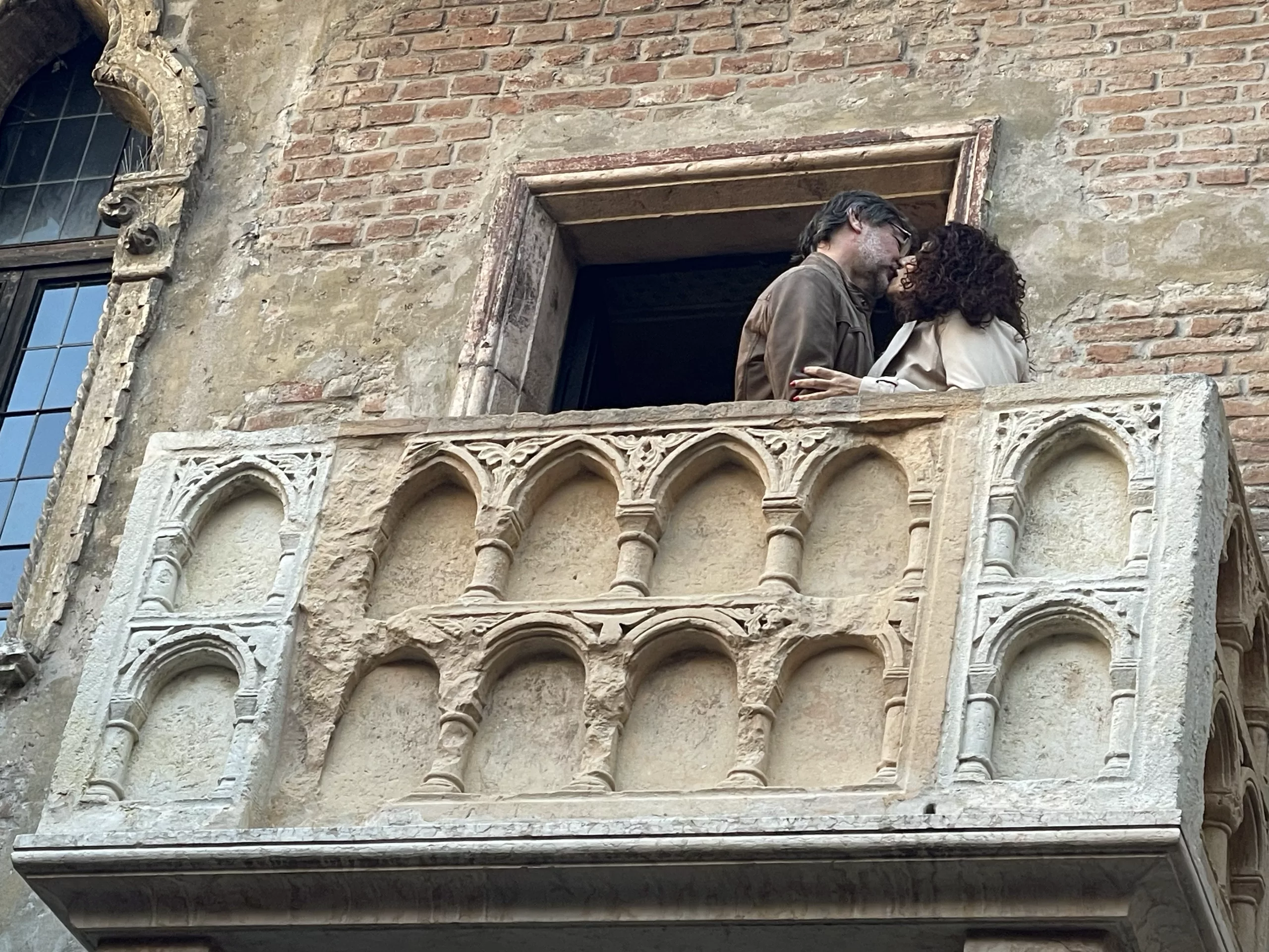 A couple kissing on Juliet’s balcony, embodying the timeless romance and passionate love inspired by the iconic scene from Shakespeare’s play
