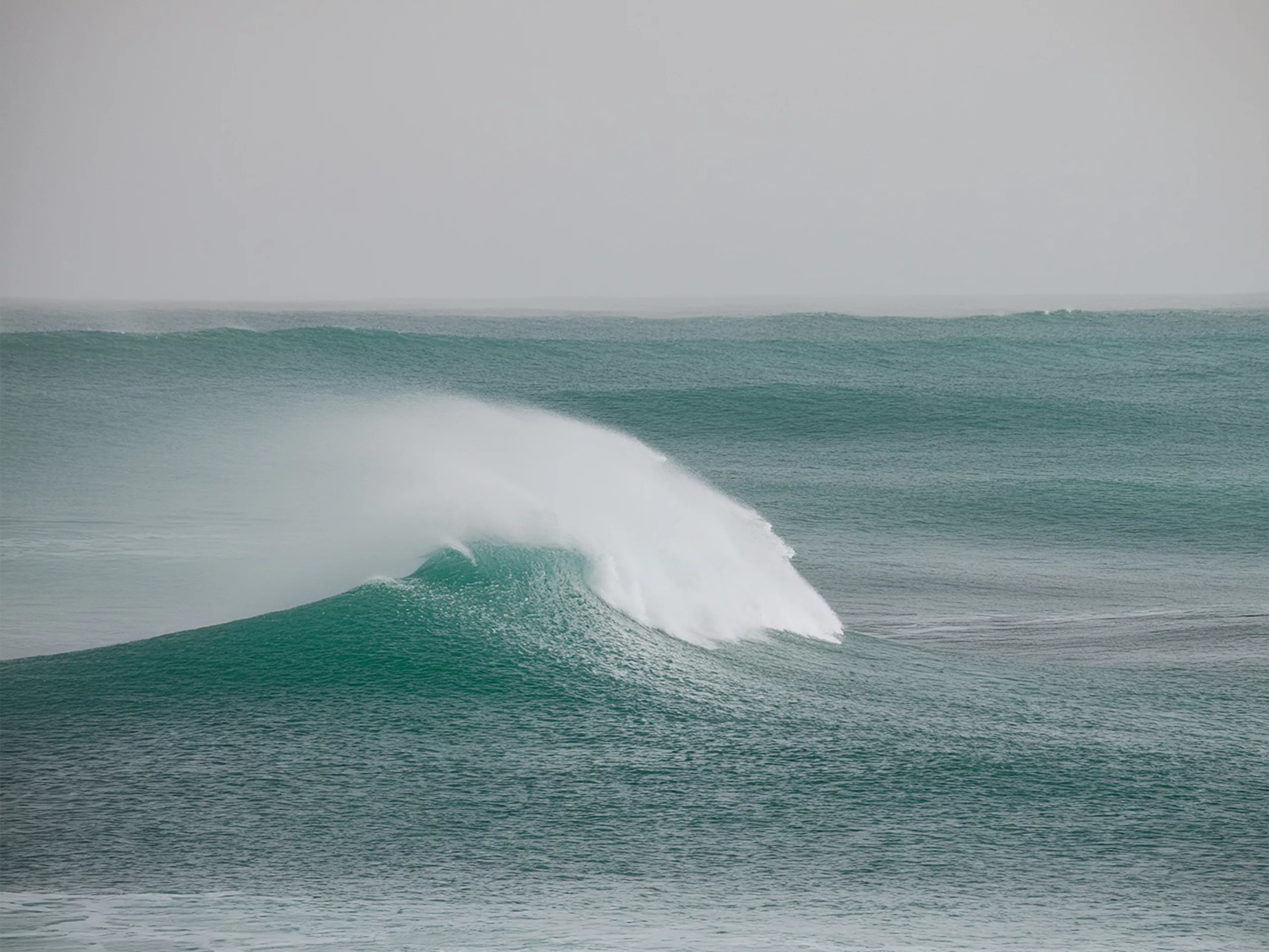 Waves dissolving into the ocean, symbolizing impermanence and the flow of the mind