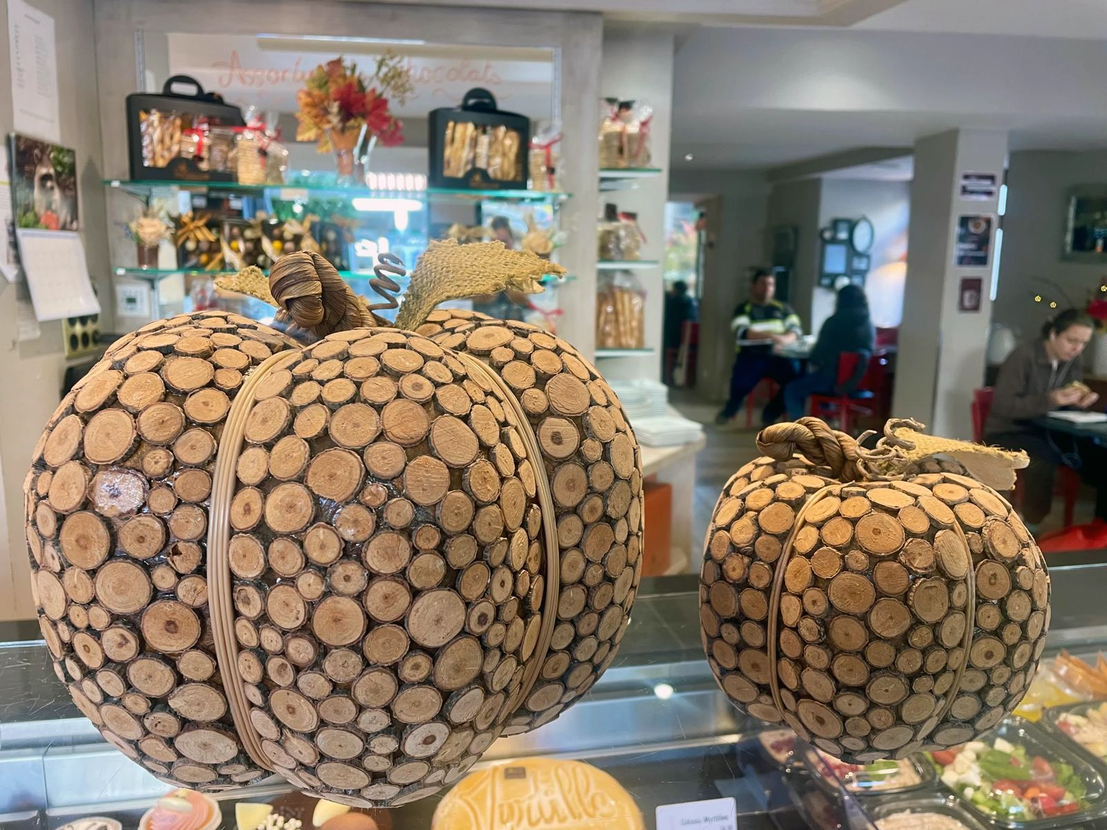 Carved wooden pumpkins among golden autumn leaves and gentle winds, symbolizing transformation, playfulness, and abundance, capturing the magic and warmth of the season